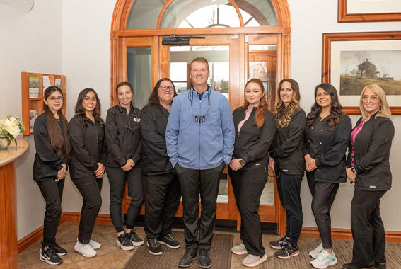 Dr. Scott Gardner standing in the waiting room of Family Dental Center with his dental team