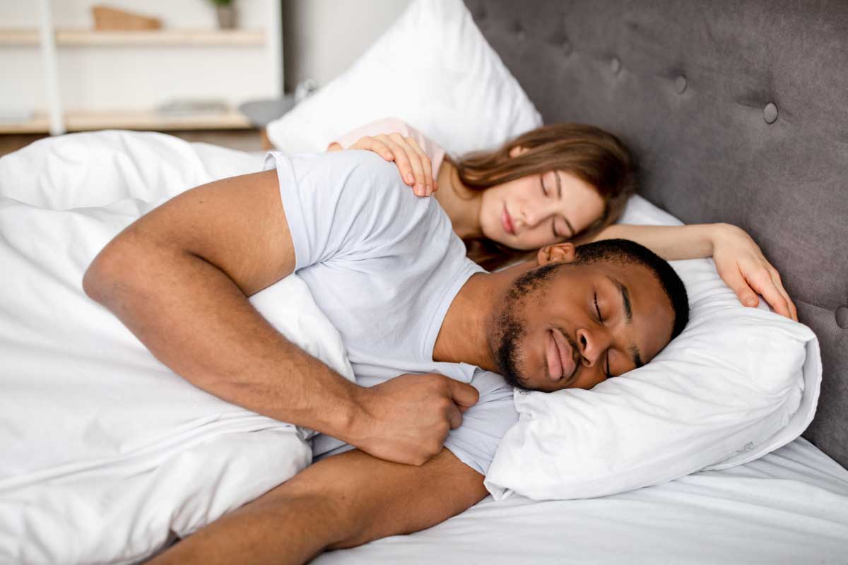 woman sleeping soundly after her husband got his sleep apnea treated at Family Dental Center